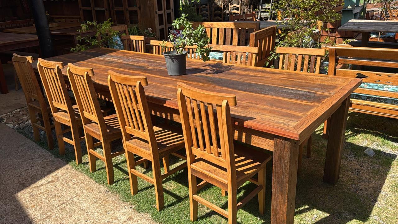 Mesa rústica de madeira maciça com cadeiras no showroom Pau Brasil